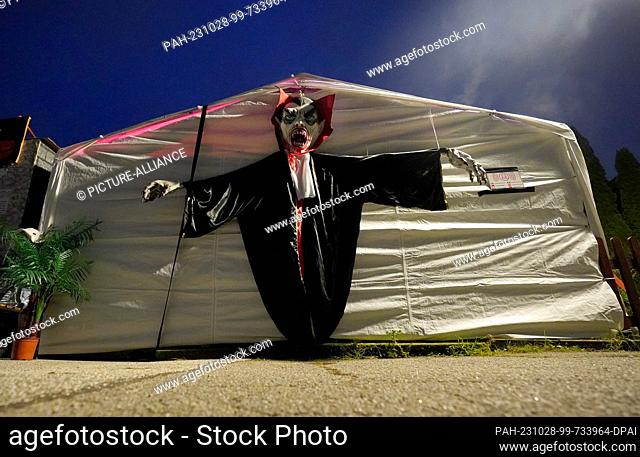 PRODUCTION - 26 October 2023, Schleswig-Holstein, Lübeck: A giant ghost figure hangs from a tent at the Halloween House in the Kücknitz district