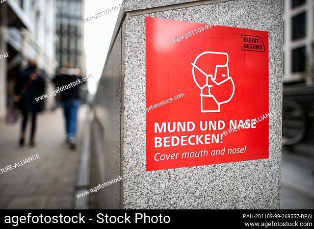 09 November 2020, North Rhine-Westphalia, Duesseldorf: A sign with a pictogram and the imprint ""Cover mouth and nose"" indicates that protective masks must be...