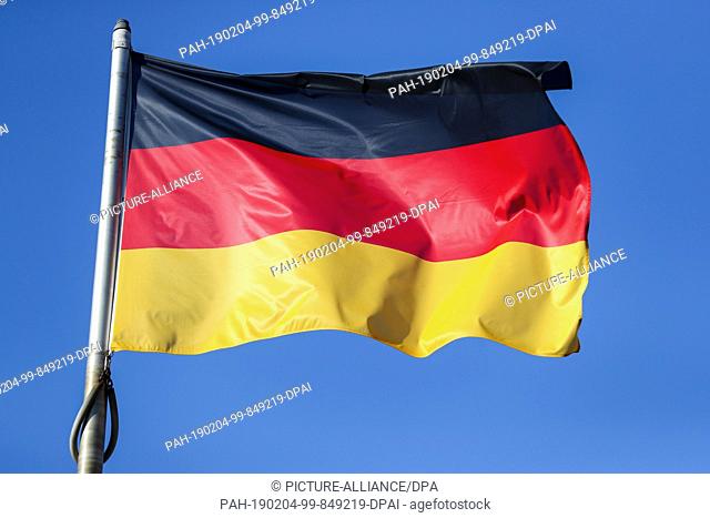 04 February 2019, Saxony, Leipzig: The German flag blows in front of a blue sky in the wind in front of the Leipzig Fair