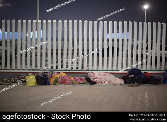 19 February 2021, Mexico, Tijuana: Dozens of migrants of Central American and Mexican origin sleep on the esplanade of the National Institute of Migration near...