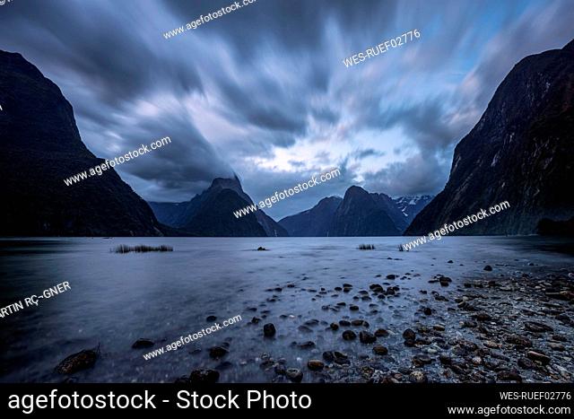 New Zealand, Southland, Long exposure of storm clouds over scenic coastline of Milford Sound