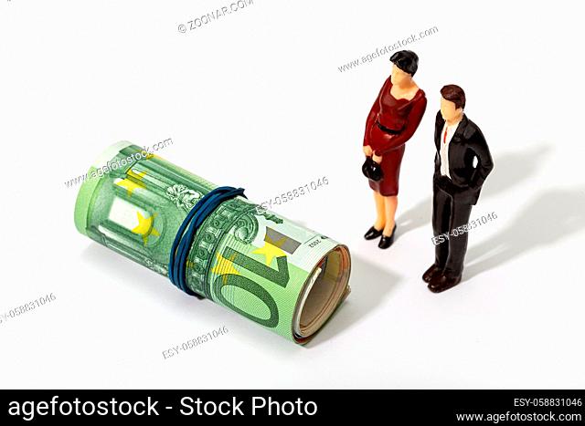 Human representation of a couple looking at a Roll of money. Finance, investment or savings concept