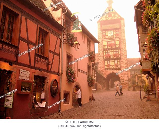 France, Europe, Alsace, Riquewihr, Haut-Rhin, L'Alsace Wine Region, Route du Vin, downtown, cobblestone pedestrian street, half-timbered buildings, clock tower