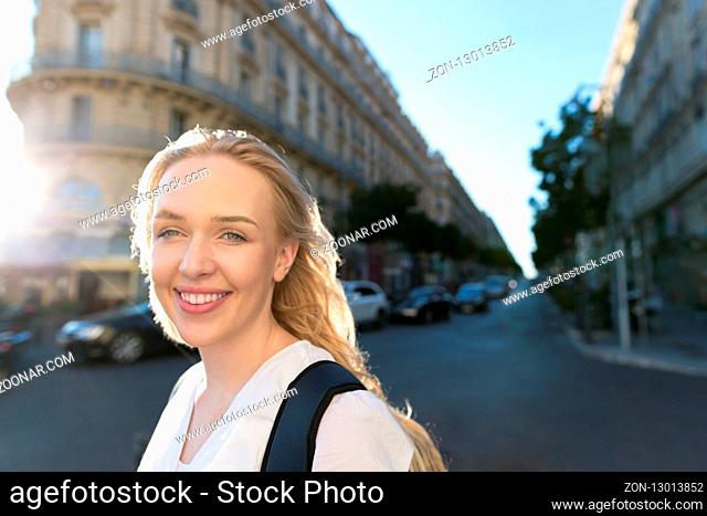 Portrait of beautiful young woman walking on the streets and exploring the city with backpack