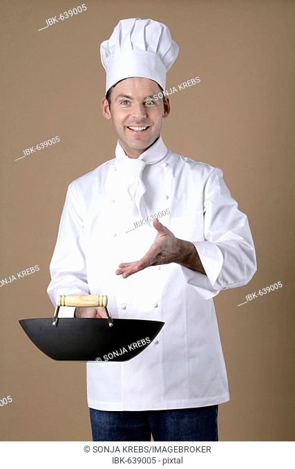 Chef gesturing to wok in his hand