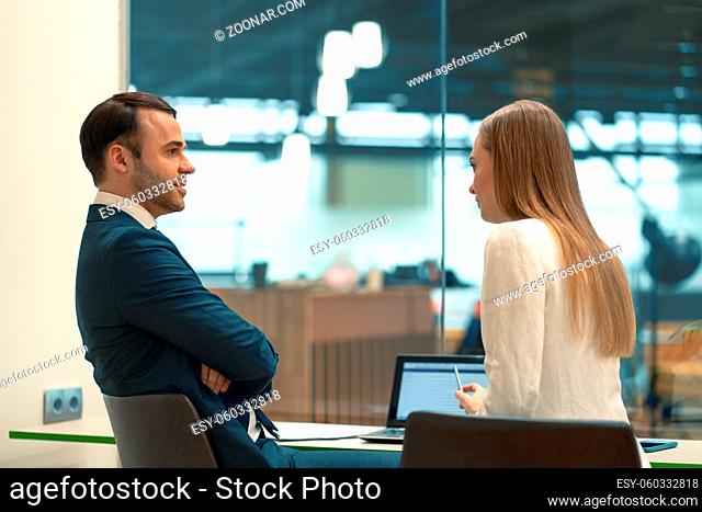 Interviewing employee beautiful girl. Close-up of two business people sitting in the workplace with documents on the table