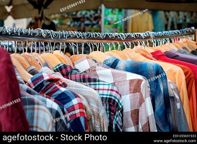 second hand fashion store, closeup of  shirts hanging on hangers