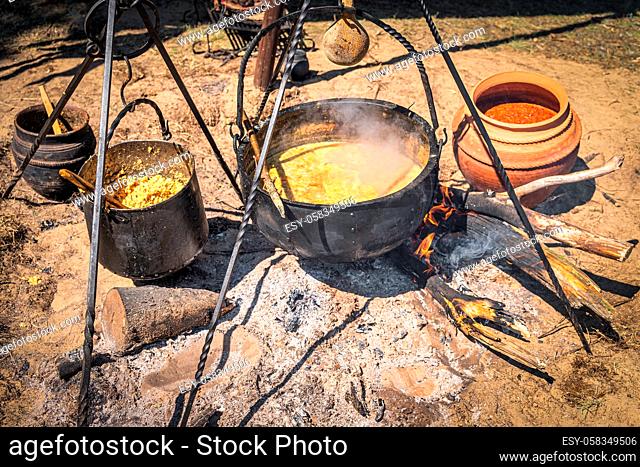 Stew or soup in iron pot or cauldron on a campfire. Homemade food at historical reenactment of Slavic or Vikings lifestyle from around 11th century, Cedynia