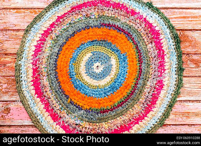 Old handicraft rug made from strips of cloth as background. Texture of a homespun doormat from different fabrics