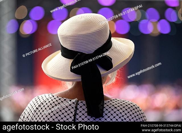 08 July 2021, Saxony, Dresden: A woman wearing a hat stands in front of the stage during the Hope Gala benefit event at the ""Filmnächte am Elbufer"" festival...