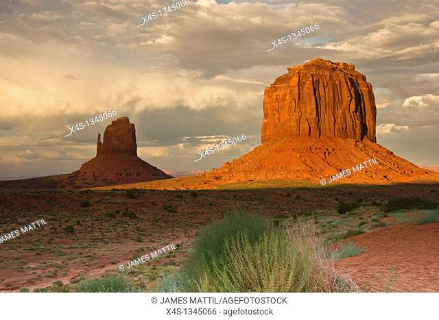 Massive sandstone pillars soar above iconic Monument Valley at sunset