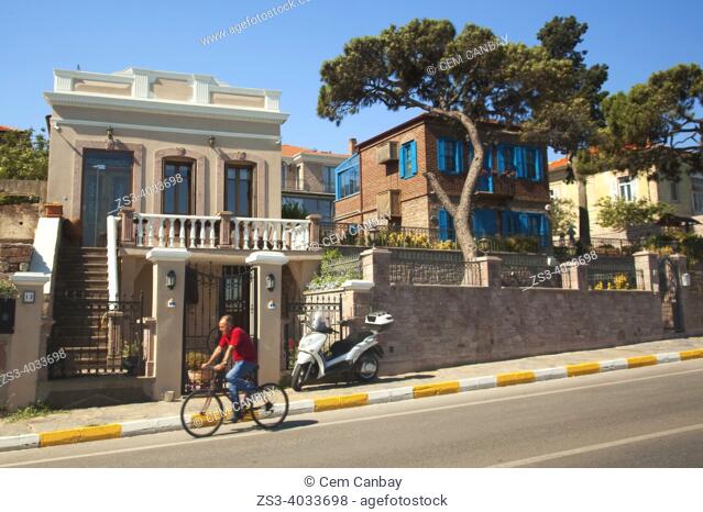 Cyclist in front of the traditional Greek-Ottoman houses with balcony in Camlik district at the center of ancient Kydonies todays Ayvalik town, Balikesir