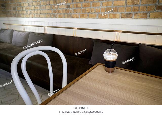 Iced milk froth coffee serving on wooden table, stock photo