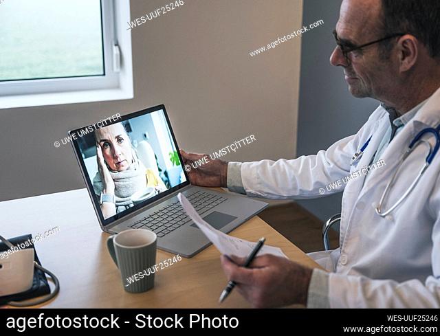 Patient discussing with doctor holding report at desk in clinic
