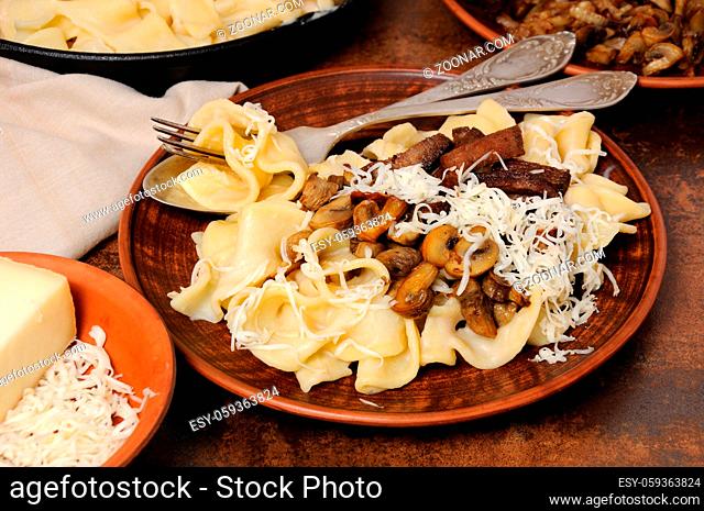 Pasta fettuccine with fried champignons, beef stroganoff, onion seasoned with cheese