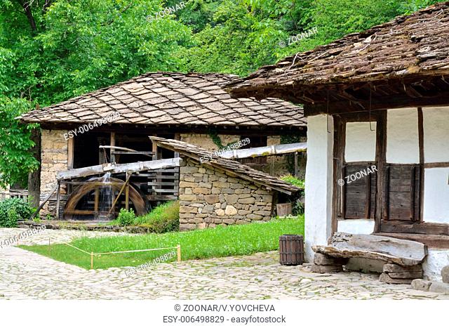 Water mill, an old house and wooden bench in Etara