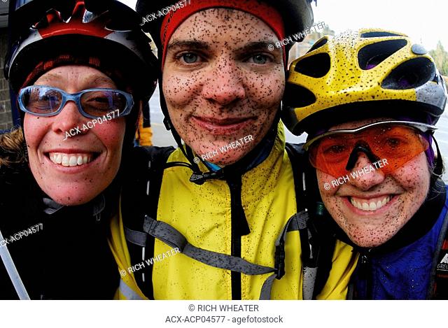 Three young women with muddy faces after mountain biking, Sunshine Coast trails. Gibsons, British Columbia, Canada