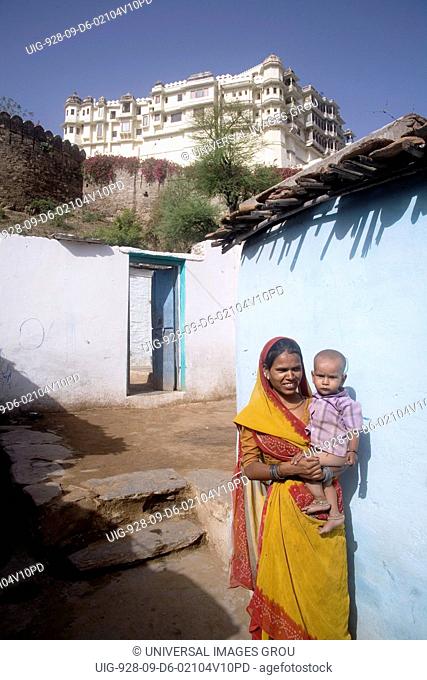 Indian Woman Standing With Her Son At Her Home Near Devi Garh Fort Palace, Now A Hotel. Village Delwara, Udaipur, Rajasthan, India