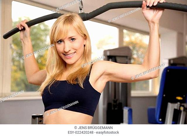 Attractive blonde woman weightlifting in a gym