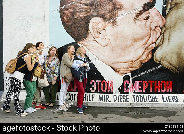Tourists taking pictures at the ''Fraternal Kiss'' mural painting by Dmitri Vrubel. Berlin, Germany