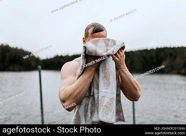 Man at lake drying himself with towel