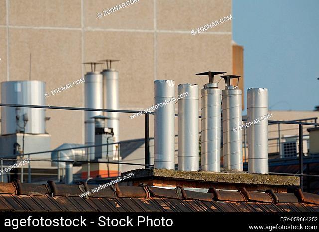 Chimneys on roofs in late afternoon light