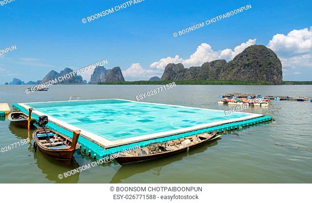 Green floating football pitch with beautiful limestone mountains background at Panyi island or Koh Panyee, floating fishing village in Phang Nga Province