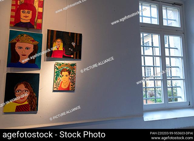 01 February 2022, Lower Saxony, Vechta: Self-painted pictures (self-portraits) of incarcerated women hang next to a barred window in Vechta Prison