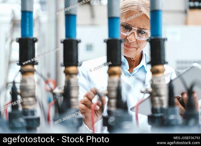 Scientist examining pipes in industry