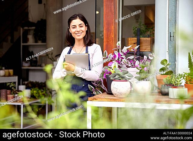 Confident female garden center worker looking at the camera