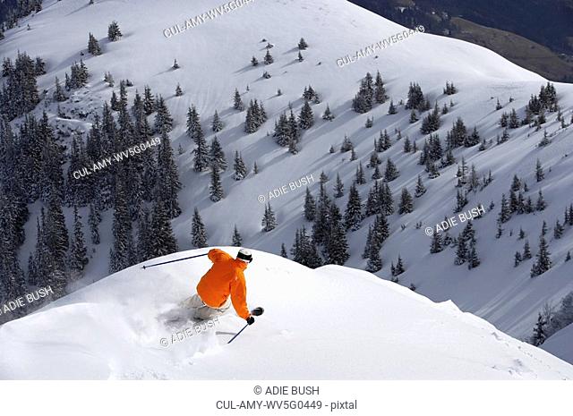 Man skiing down snow mountain slope, overhead view