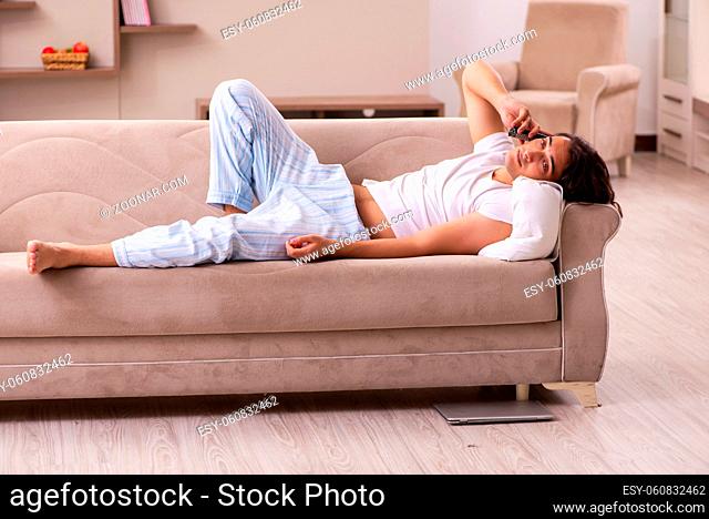 Young male student in oversleeping concept at home