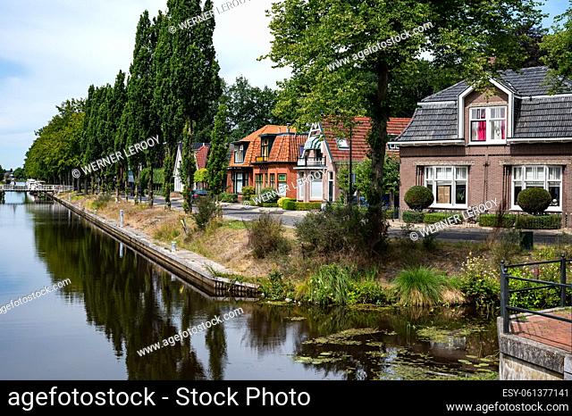 Oosterwolde, Friesland, The Netherlands - Reflected houses and boats at the banks fo the canal with natural surroundings