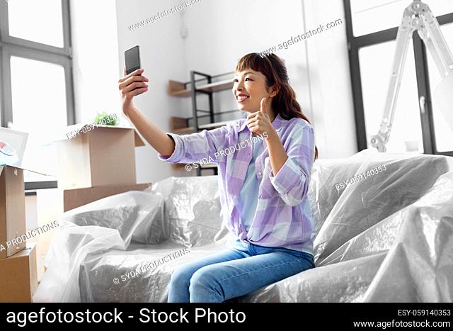 woman with phone having video call at new home