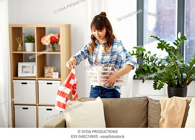 asian woman picking dirty laundry at home