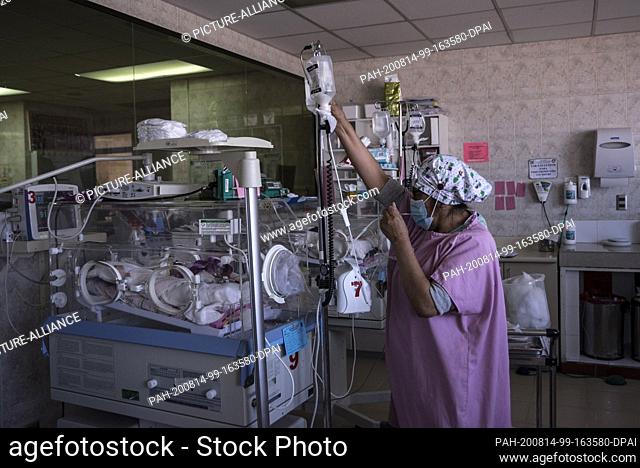13 August 2020, Bolivia, La Paz: A nurse takes care of a newborn with an illness in the intensive care unit of the women's hospital