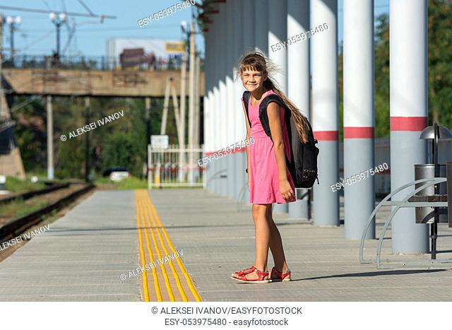 The eight-year-old girl on the platform of the train station looked funny in the frame