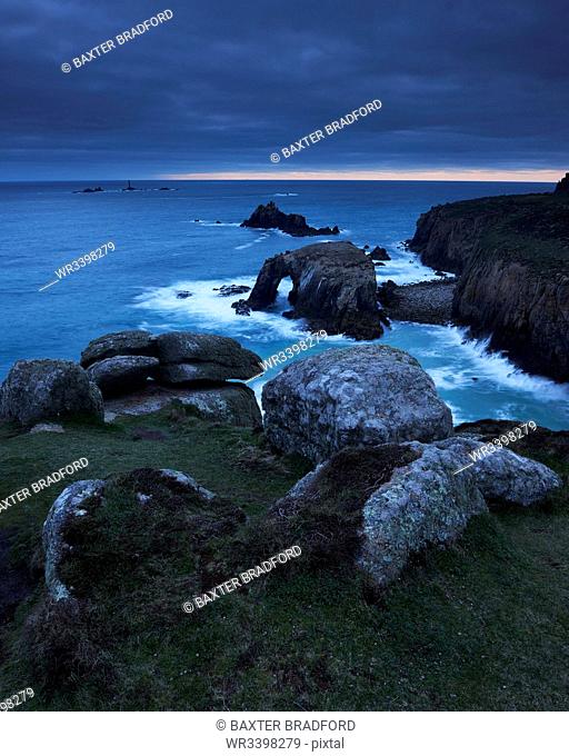 Sunset at Land's End over Enys Dodman rock arch, Longships Lighthouse, Cornwall, England, United Kingdom, Europe