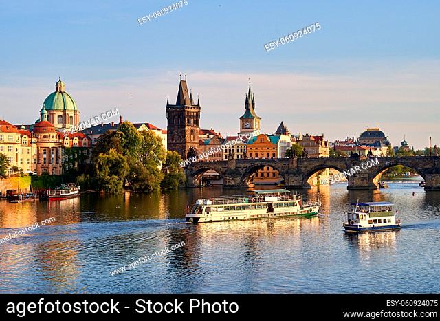 Charles bridge in Prague, Czech Republic with many tourist ships and boats