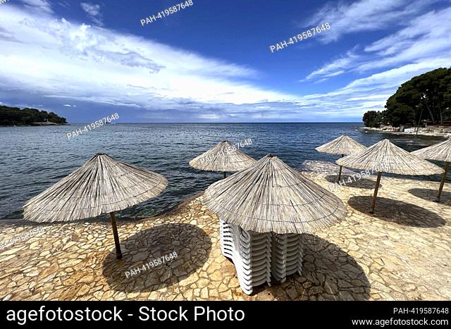Plava Laguna, Adriatic coast near Porec / Croatia, beach. Empty beach, umbrellas and stacked chairs, deserted, no vacationers, deserted, empty, no bathers