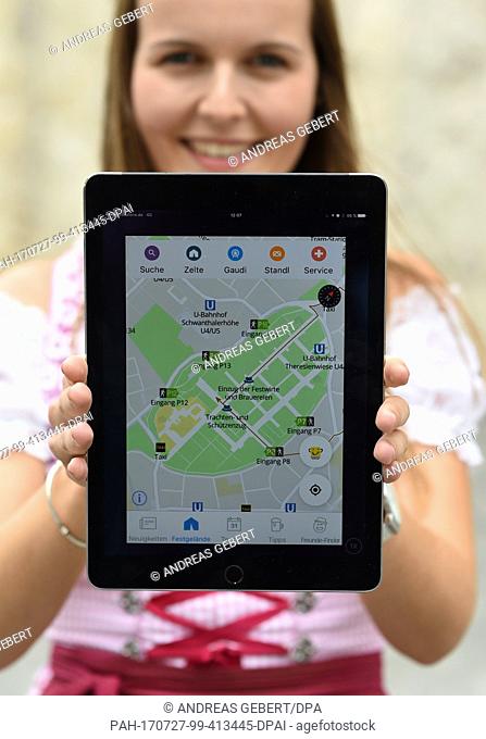 Isabelle Huber, an employee of the city of Munish, holds a tablet displaying a new Oktoberfest city app at a press conference at which the city announced the...