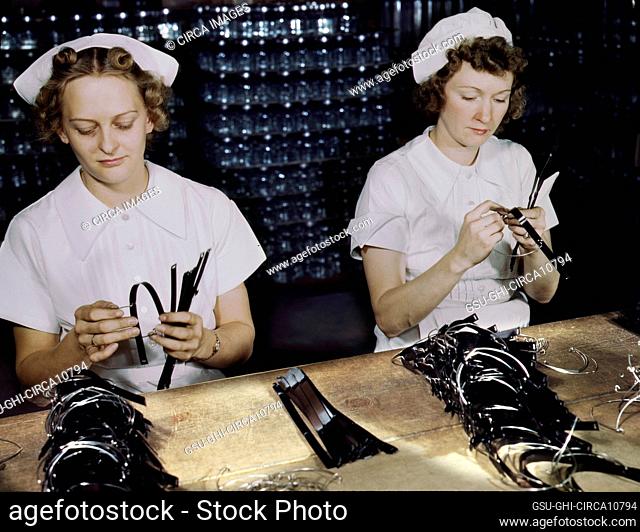 Two Female War Production Workers, Eva Herzberg and Elve Burnham, assembling bands for Transfusion Donor Bottles, Baxter Laboratories, Glenview, Illinois, USA