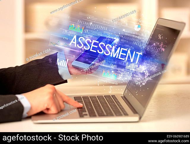 Closeup of businessman hands working on laptop with ASSESSMENT inscription, succesfull business concept