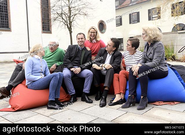 Group of friends sitting on large cushions outdoors