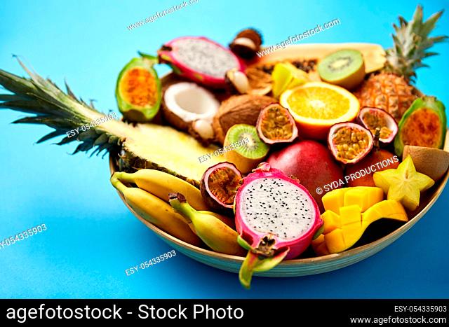 plate of exotic fruits on blue background