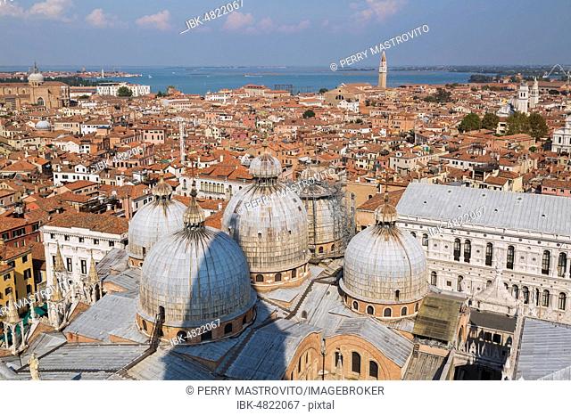 St Mark's Basilica with Romanesque domes and ornate Gothic and Byzantine architectural details plus the Doge's Palace built in the Venetian Gothic architectural...