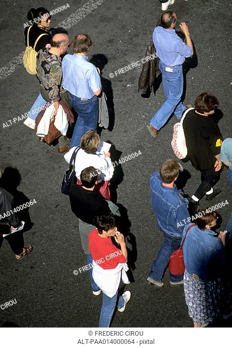 Group of people standing on asphalt, high angle view