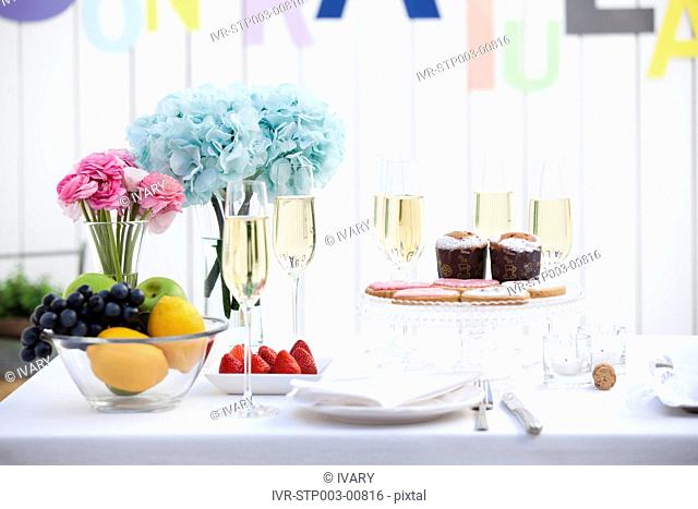 Close-up of wine glass with fruits and cake on table