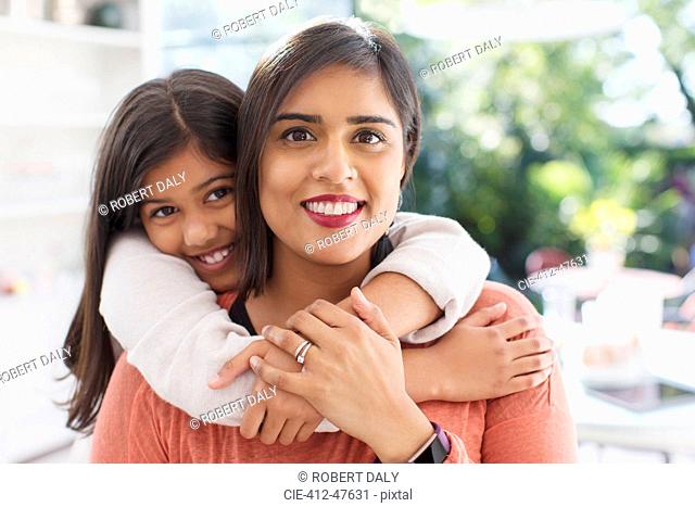 Portrait happy, affectionate mother and daughter hugging