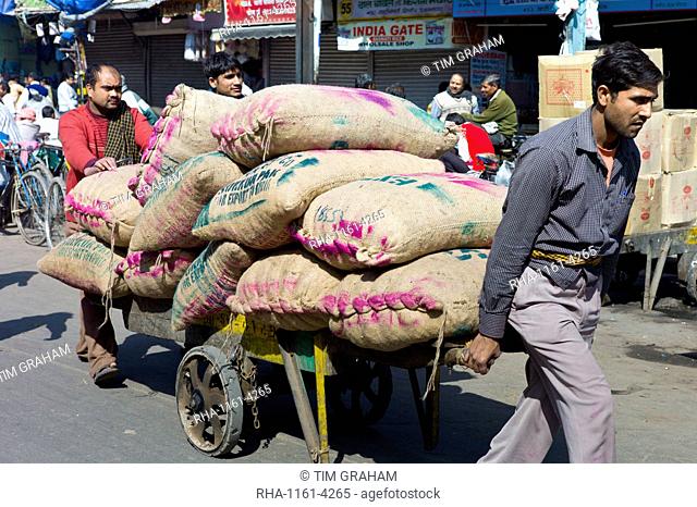 Porters with sacks of dates at Khari Baoli spice and dried foods market, Old Delhi, India